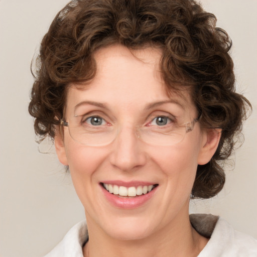 Joyful white adult female with medium  brown hair and green eyes