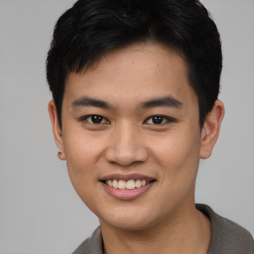 Joyful asian young-adult male with short  black hair and brown eyes