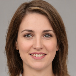 Joyful white young-adult female with medium  brown hair and green eyes