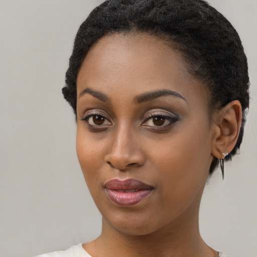 Joyful black young-adult female with short  black hair and brown eyes