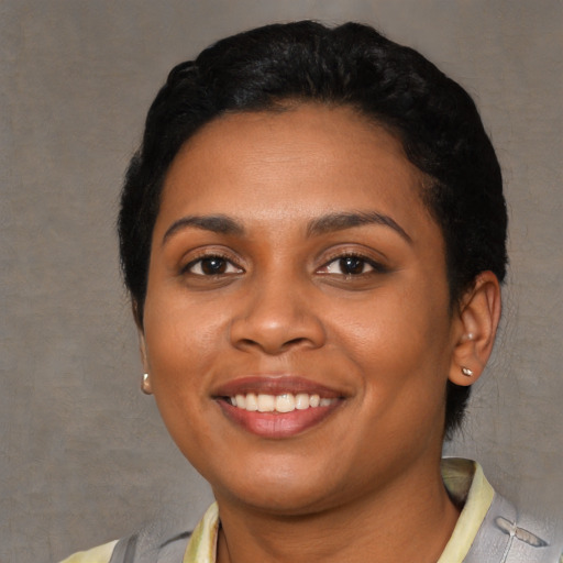 Joyful latino young-adult female with short  black hair and brown eyes