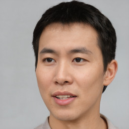 Joyful asian young-adult male with short  brown hair and brown eyes