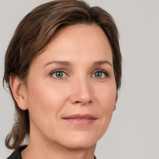 Joyful white adult female with medium  brown hair and grey eyes