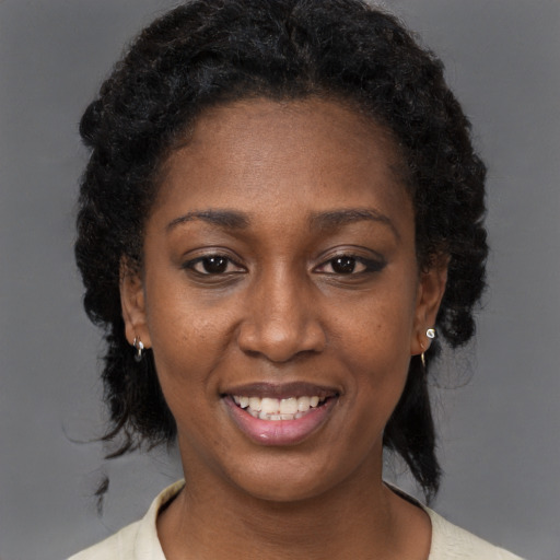 Joyful black young-adult female with medium  brown hair and brown eyes