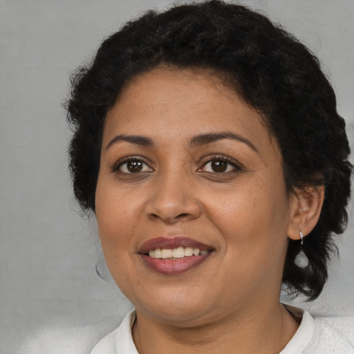 Joyful latino adult female with short  brown hair and brown eyes