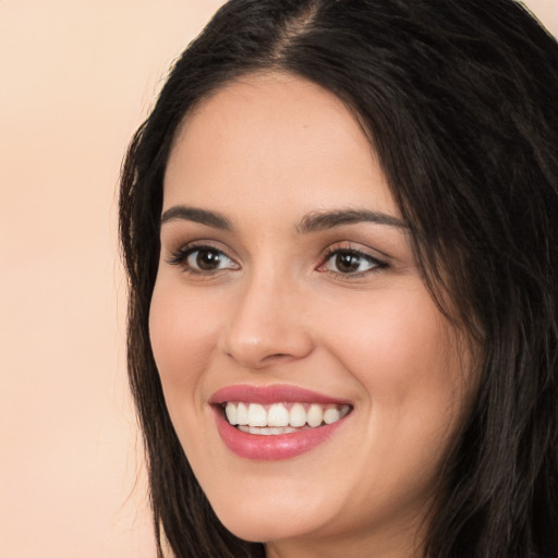 Joyful white young-adult female with long  black hair and brown eyes