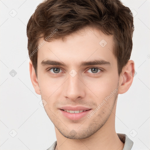 Joyful white young-adult male with short  brown hair and grey eyes