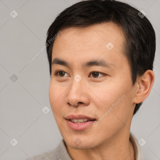 Joyful asian young-adult male with short  black hair and brown eyes