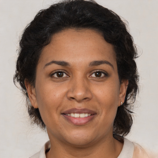 Joyful latino adult female with medium  brown hair and brown eyes