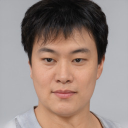 Joyful asian young-adult male with short  brown hair and brown eyes