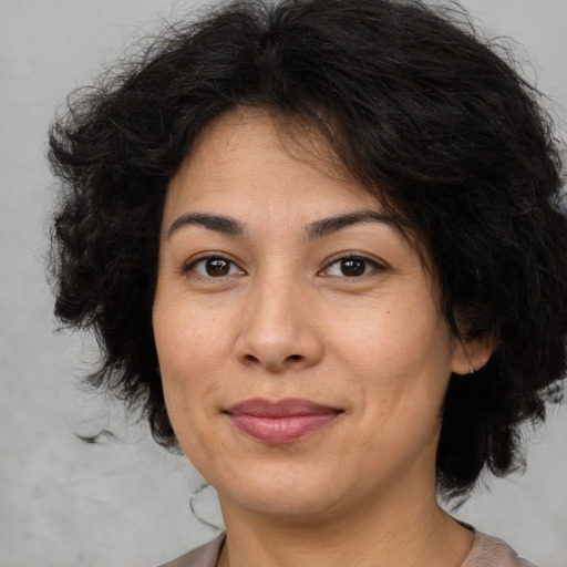 Joyful latino adult female with medium  brown hair and brown eyes