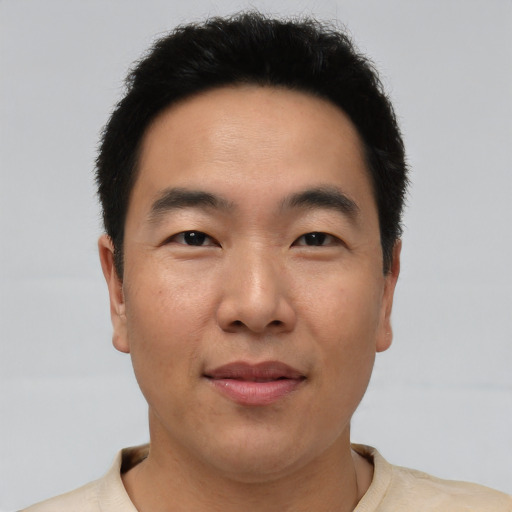 Joyful asian young-adult male with short  brown hair and brown eyes