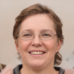 Joyful white adult female with medium  brown hair and blue eyes