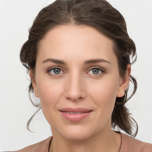 Joyful white young-adult female with medium  brown hair and grey eyes