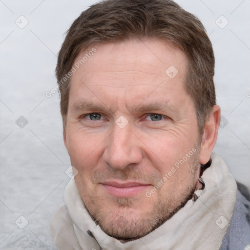 Joyful white adult male with short  brown hair and grey eyes