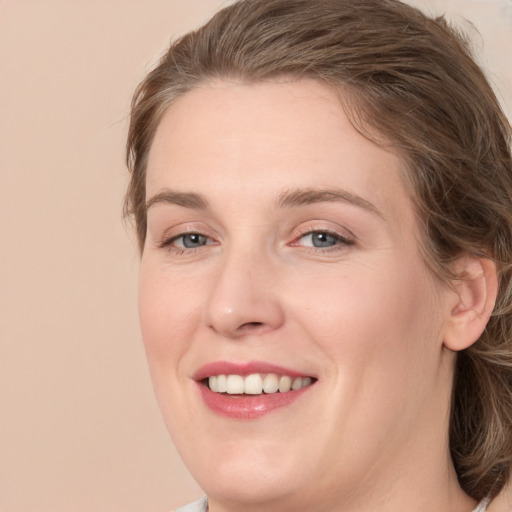 Joyful white young-adult female with medium  brown hair and grey eyes