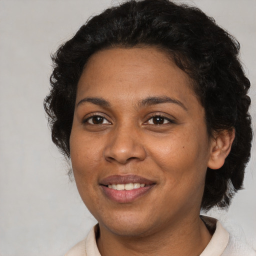 Joyful black adult female with short  brown hair and brown eyes