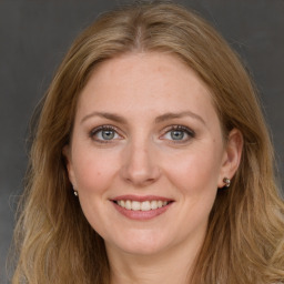 Joyful white young-adult female with long  brown hair and blue eyes