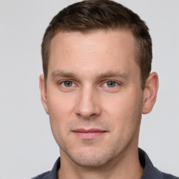 Joyful white young-adult male with short  brown hair and grey eyes