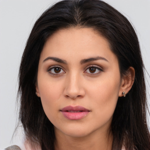 Joyful latino young-adult female with long  brown hair and brown eyes