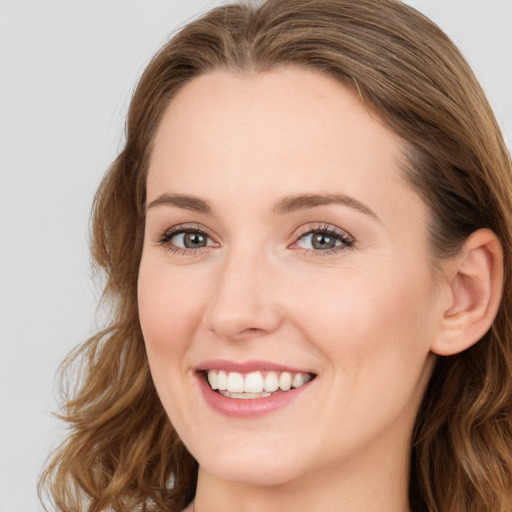 Joyful white young-adult female with long  brown hair and blue eyes