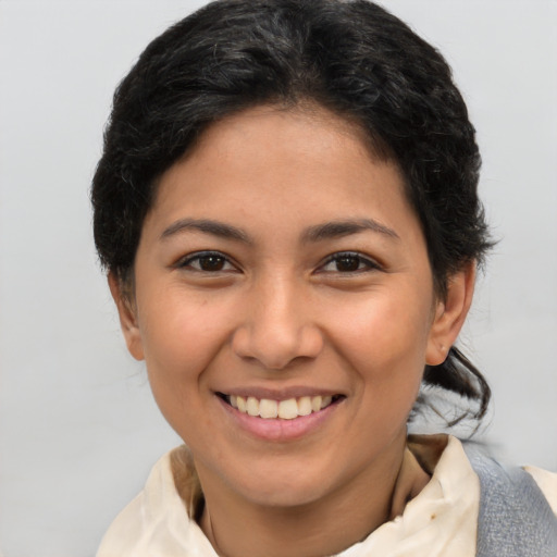 Joyful latino young-adult female with short  brown hair and brown eyes