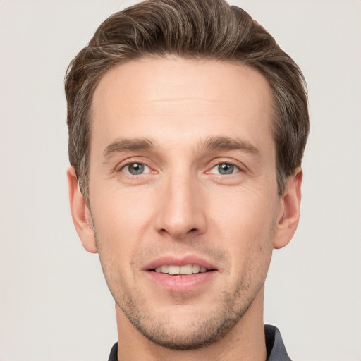 Joyful white young-adult male with short  brown hair and grey eyes