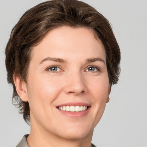 Joyful white young-adult female with short  brown hair and grey eyes