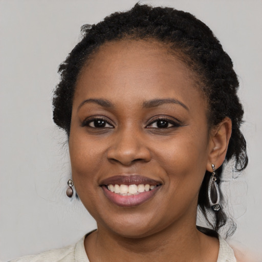 Joyful black young-adult female with long  black hair and brown eyes