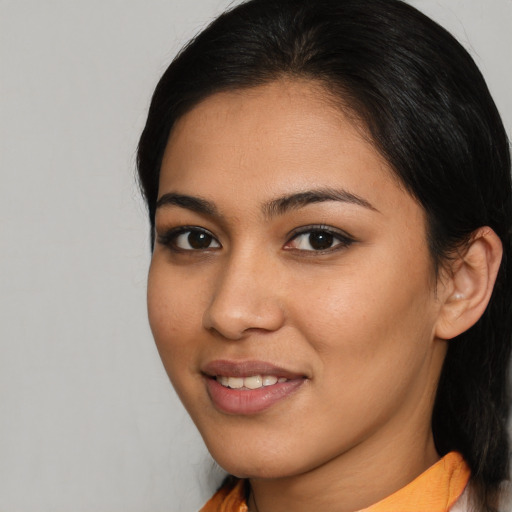 Joyful latino young-adult female with medium  brown hair and brown eyes