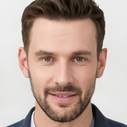 Joyful white young-adult male with short  brown hair and grey eyes