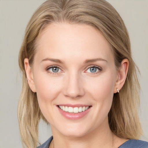 Joyful white young-adult female with long  brown hair and blue eyes