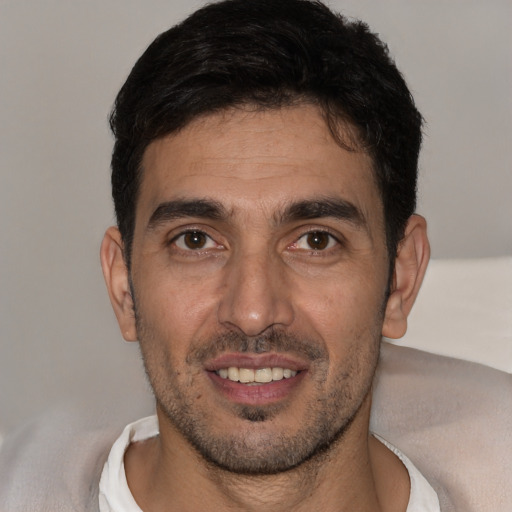 Joyful white young-adult male with short  black hair and brown eyes