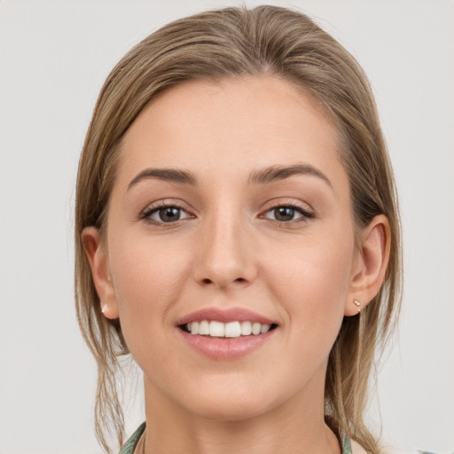 Joyful white young-adult female with long  brown hair and grey eyes