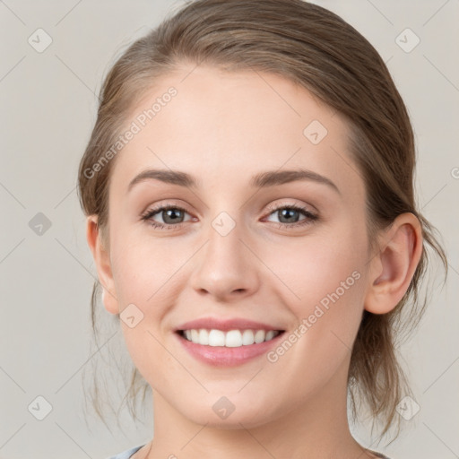 Joyful white young-adult female with medium  brown hair and grey eyes