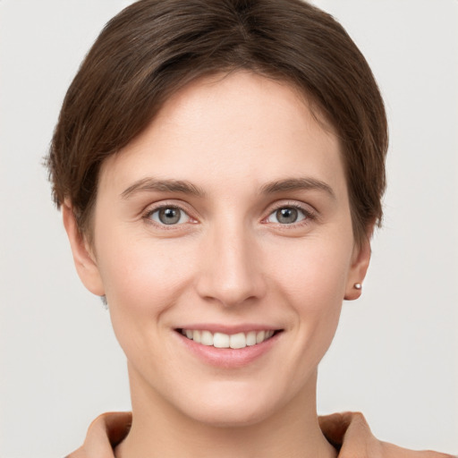 Joyful white young-adult female with short  brown hair and grey eyes