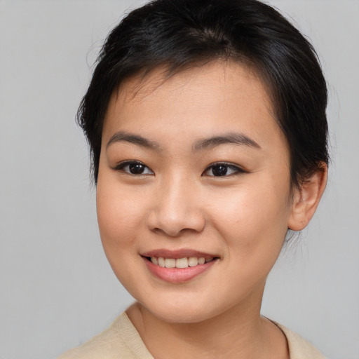 Joyful asian young-adult female with short  brown hair and brown eyes
