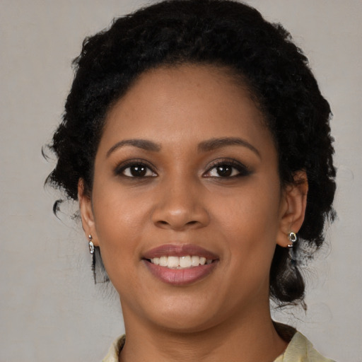 Joyful black young-adult female with medium  brown hair and brown eyes