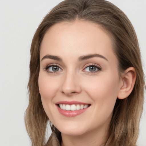 Joyful white young-adult female with long  brown hair and blue eyes