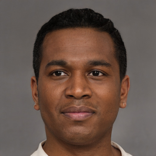 Joyful black young-adult male with short  black hair and brown eyes
