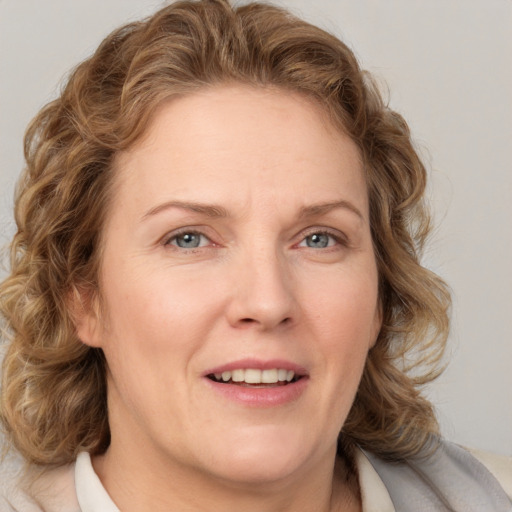 Joyful white adult female with medium  brown hair and blue eyes