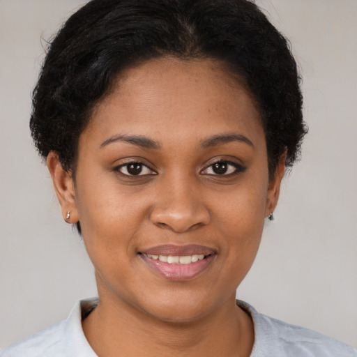 Joyful black young-adult female with short  brown hair and brown eyes