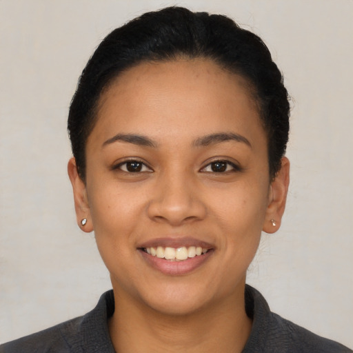 Joyful latino young-adult female with short  black hair and brown eyes