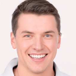 Joyful white young-adult male with short  brown hair and grey eyes