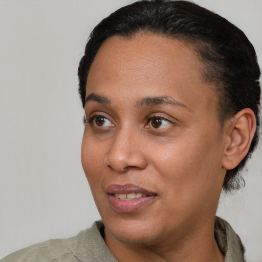 Joyful black adult female with short  black hair and brown eyes