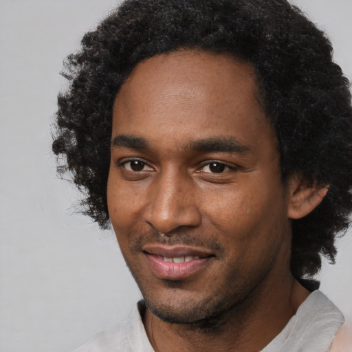 Joyful black young-adult male with short  black hair and brown eyes
