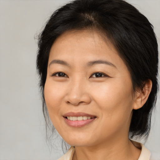 Joyful asian adult female with medium  brown hair and brown eyes