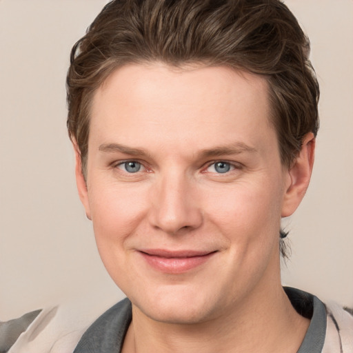 Joyful white young-adult male with short  brown hair and grey eyes