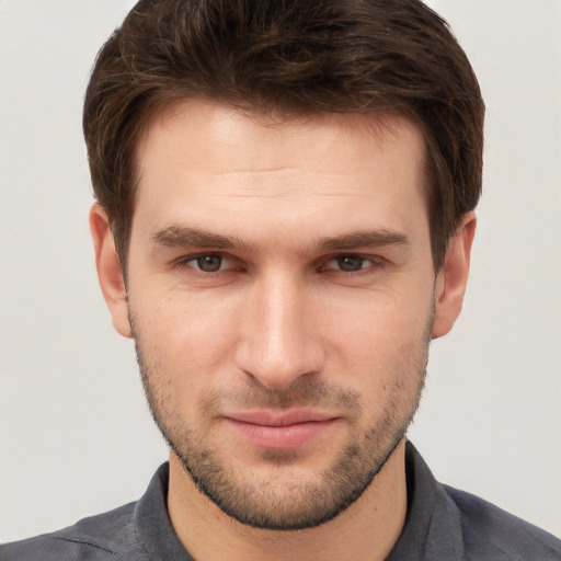 Joyful white young-adult male with short  brown hair and grey eyes