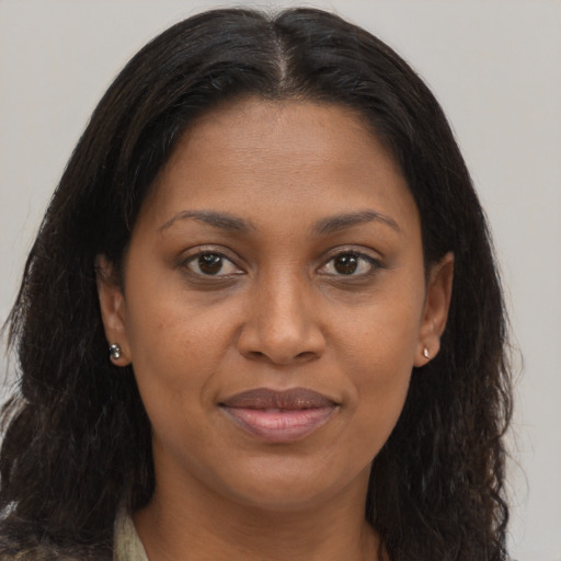 Joyful black young-adult female with long  brown hair and brown eyes